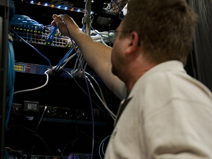 Técnico revisando conexiones de red en un rack de servidores (foto ilustrativa)