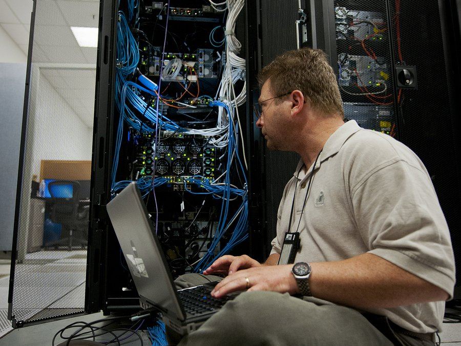 Técnico de Cybertec revisando un servidor con su computador portátil (foto ilustrativa)