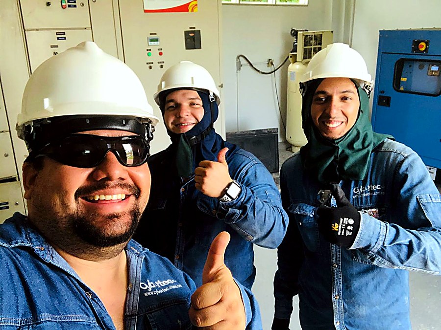 Técnicos de Cybertec con equipo de protección frente a un tablero eléctrico