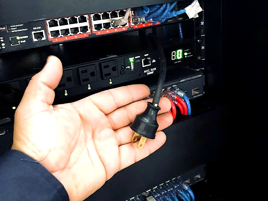 Técnico de Cybertec revisando una conexión eléctrica dentro de un rack