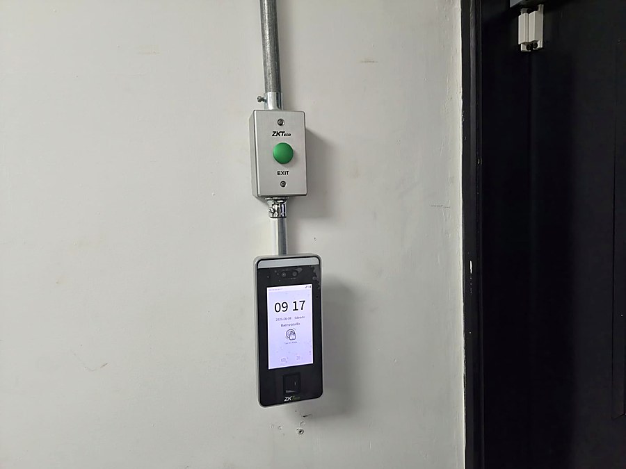 Lector biométrico de control de acceso ZKTeco junto a una puerta