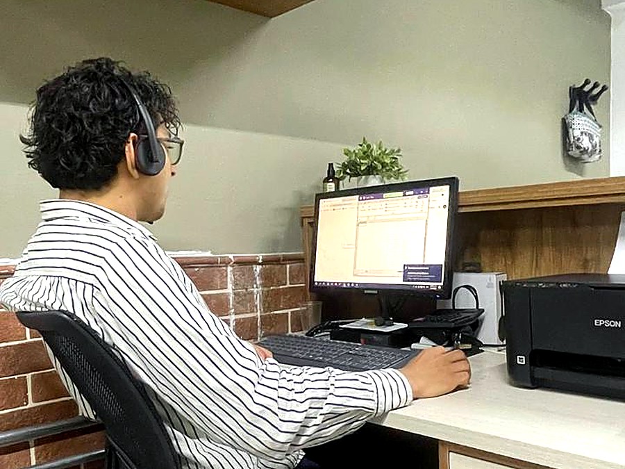 Técnico de Cybertec atendiendo soporte con diadema frente a su computador